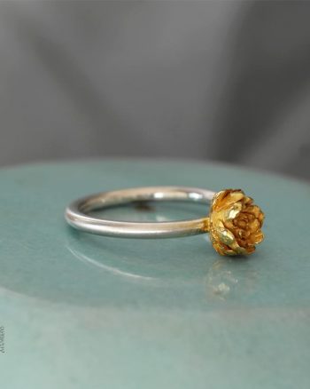 anillo de plata y oro con diseño botánico de flor